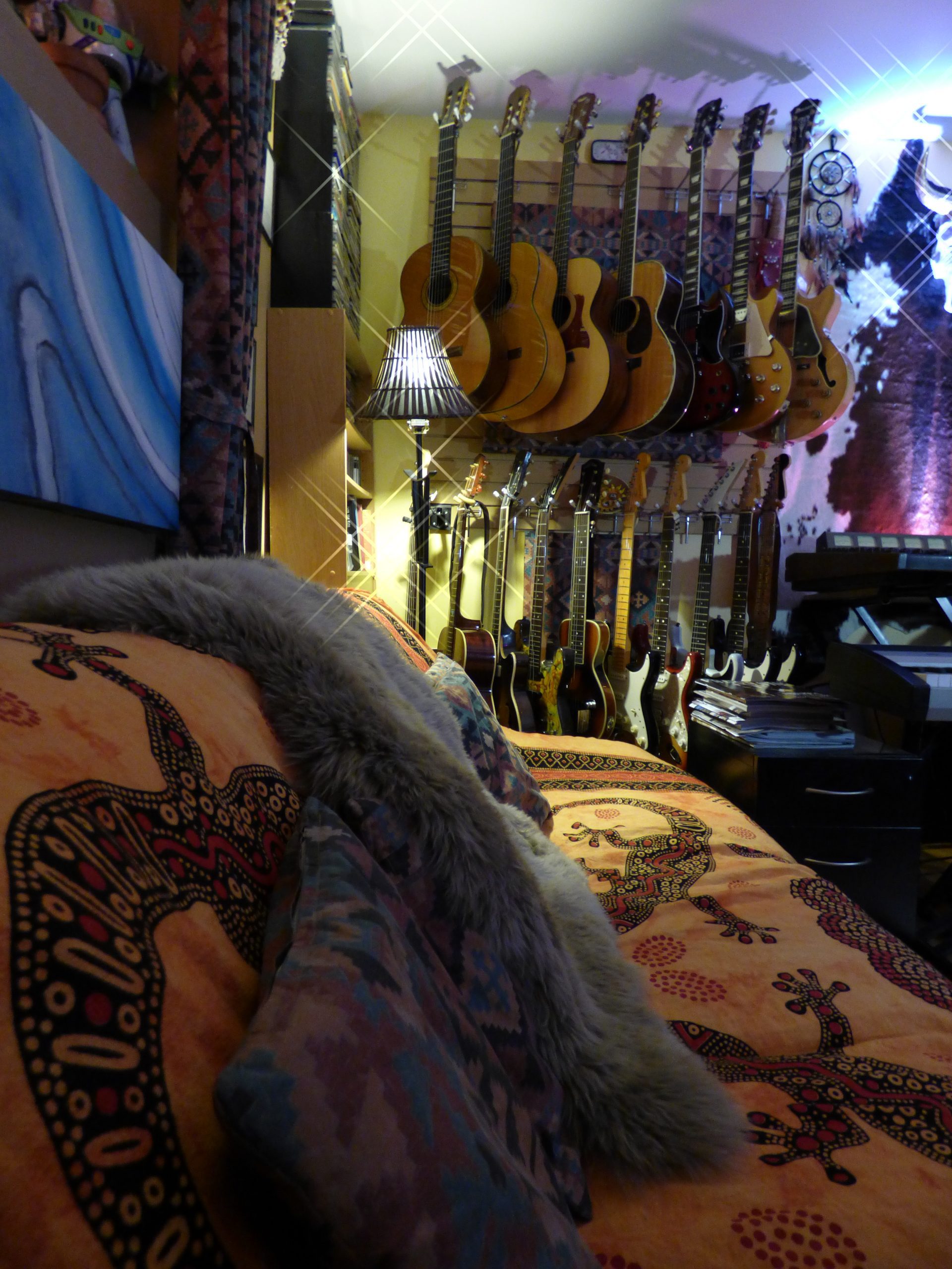 SEGPOP Studios control room with guitars on the wall flanked by a comfy couch.